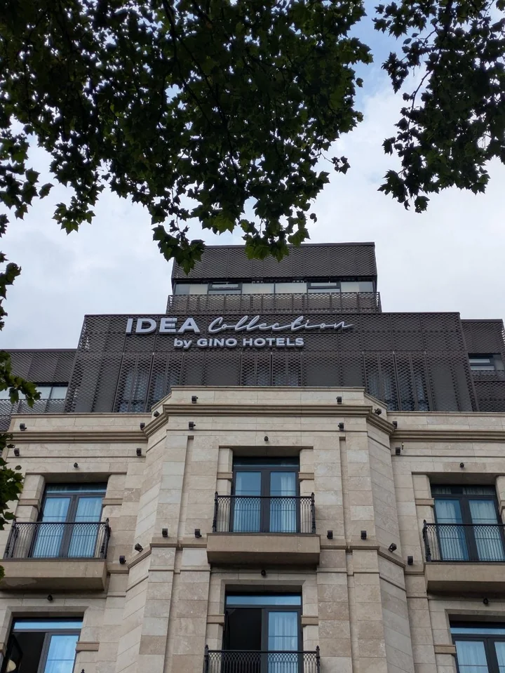 An English-language hotel sign on the decorative grille on the upper facade