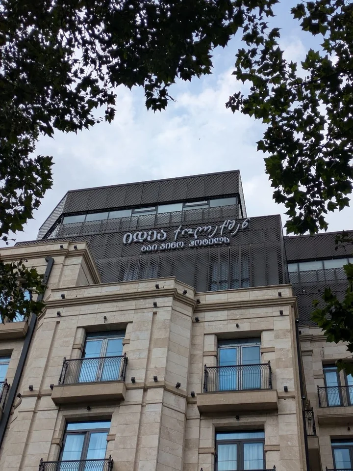 A Georgian-language hotel sign on the upper part of the facade